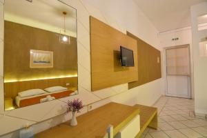a room with a bed and a tv on a wall at Epavlis Beach Resort in Porto Heli