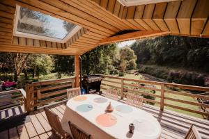 a patio with a table and chairs on a wooden deck at Gîte du Moulin in Pluvigner