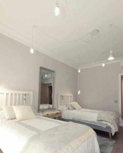 a bedroom with two beds and a mirror at GuardaViñas24 in Logroño