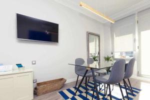 a dining room with a table and chairs and a tv at GuardaViñas24 in Logroño