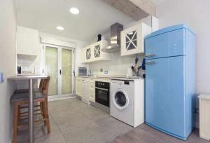 a kitchen with a blue refrigerator and a washing machine at GuardaViñas24 in Logroño