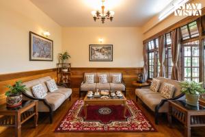 a living room with two couches and a table at StayVista at Thangsing Farmhouse 4 BHK Pahadi villa with Gazebo, Indoor-Outdoor Games near Sikkim in Kaluk