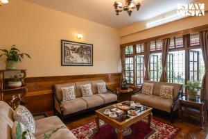 a living room with two couches and a table at StayVista at Thangsing Farmhouse 4 BHK Pahadi villa with Gazebo, Indoor-Outdoor Games near Sikkim in Kaluk