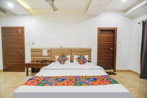 a bedroom with a large bed with a colorful blanket at Hotel Apple Tree in Guwahati +27 photos