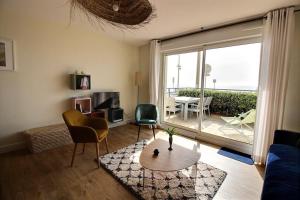 una sala de estar con un sofá y una mesa en Annonce professionnelle. Appartement en rdc face mer, 2 chambres pour 4 à 6 personnes HARDELOT, en Hardelot-Plage