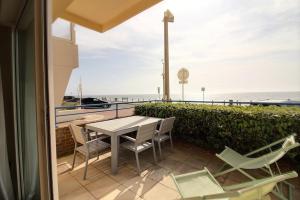 Una mesa y sillas en un balcón con vista al mar. en Annonce professionnelle. Appartement en rdc face mer, 2 chambres pour 4 à 6 personnes HARDELOT, en Hardelot-Plage