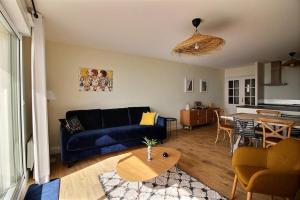 Una sala de estar con un sofá azul y una mesa. en Annonce professionnelle. Appartement en rdc face mer, 2 chambres pour 4 à 6 personnes HARDELOT, en Hardelot-Plage