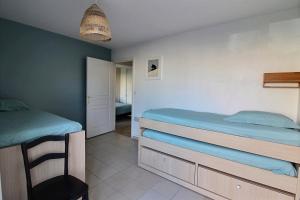 Un dormitorio con dos camas y una silla dentro. en Annonce professionnelle. Appartement en rdc face mer, 2 chambres pour 4 à 6 personnes HARDELOT, en Hardelot-Plage