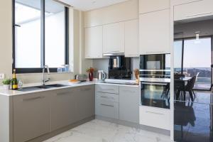 a white kitchen with white cabinets and a table at Villa Eliz in Kalkan