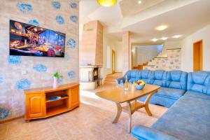 a living room with a blue couch and a table at Guest House Andrea in Rogachevo