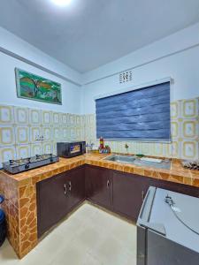 a kitchen with a sink and a large window at Fly Africa Village in Arusha