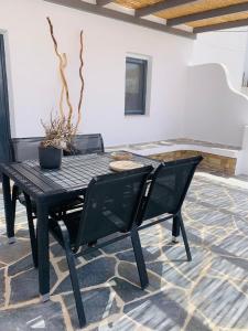 a black table and chairs with a potted plant at Mazi stin Io in Ios Chora