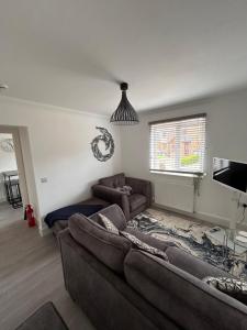 a living room with a couch and a tv at The Loft and The Den Apartments in Sandown
