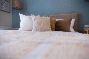 a bed with white sheets and pillows in a bedroom at Milla Apartamenty in Zamość