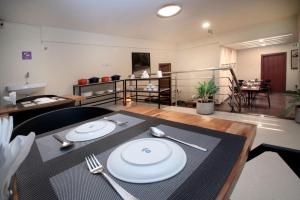 a dining room with a table with plates and silverware at Purple Cloud Urban Bangalore in Bangalore