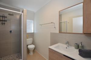 a bathroom with a toilet and a sink and a mirror at Seaforever Apartment in Yzerfontein +17 photos