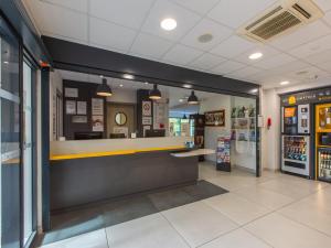 a fast food restaurant with a counter and refrigerator at Premi&egrave;re Classe Chartres Sud - Barjouville in Chartres