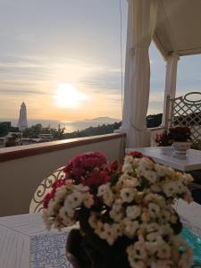 a table with flowers on top of a balcony at B&B Villa Cristina in Anacapri
