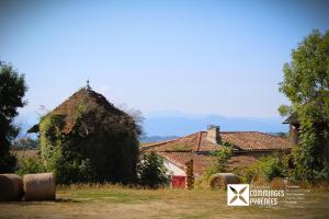 a house with a thatched roof with hay bales at MOBIL-HOME Ferme La Fée Spiruline AURIGNAC in Aurignac +16 photos