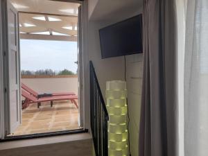 a living room with a tv and a sliding glass door at B&B MARRELLA in Capilungo