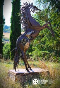 a statue of a peacock standing on a platform at MOBIL-HOME Ferme La Fée Spiruline AURIGNAC in Aurignac