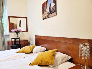 a bedroom with a bed with white sheets and yellow pillows at DReAM Post Aparthotel in Kraków