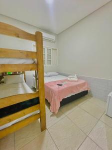 a bedroom with a bunk bed with a pink blanket at Brisa mar pousada in Ubatuba