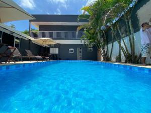 a large swimming pool with blue water in front of a building at Brisa mar pousada in Ubatuba +26 photos