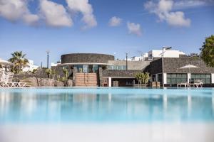 a large swimming pool in front of a house at Caybeach Papagayos in Playa Blanca