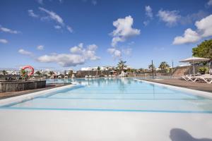 a swimming pool at a resort with a sky background at Caybeach Papagayos in Playa Blanca
