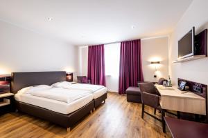 a hotel room with a bed and a desk at Weinhotel Restaurant Klostermühle in Ockfen +71 photos