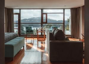 salon z kanapą i dużym oknem w obiekcie Boutique Hotel & Spa Bosque del Nahuel w mieście Bariloche