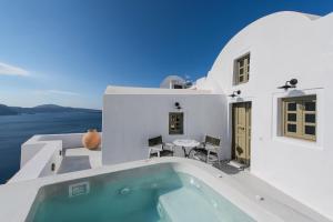 a villa with a swimming pool and a house at Rhenia's Villas in Oia