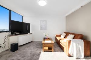 a living room with a couch and a flat screen tv at CT&Mountain View on High level Riverfont Carpark in Brisbane