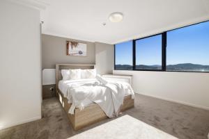 a bedroom with a bed and a large window at CT&Mountain View on High level Riverfont Carpark in Brisbane