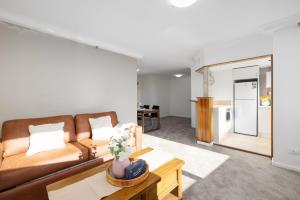 a living room with a couch and a table at CT&Mountain View on High level Riverfont Carpark in Brisbane
