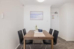 a dining room with a wooden table and black chairs at CT&Mountain View on High level Riverfont Carpark in Brisbane