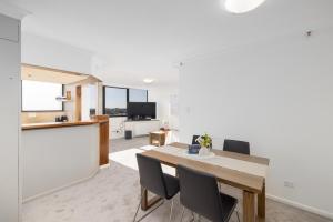 a dining room and living room with a table and chairs at CT&Mountain View on High level Riverfont Carpark in Brisbane +6 photos