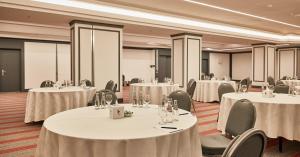 a conference room with tables and chairs with white linens at Erbil International Hotel in Erbil +41 photos