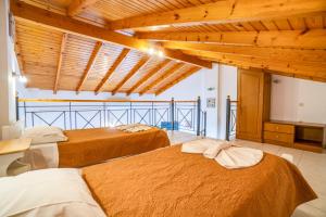 two beds in a room with wooden ceilings at Anna Studio and Maisonettes in Arillas +81 photos