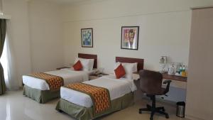 Postel nebo postele na pokoji v ubytování Nestor Hotel, Mumbai