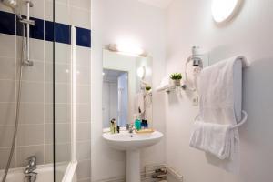 图卢兹Nemea Appart Hotel Toulouse Aéroport的带水槽和淋浴的白色浴室