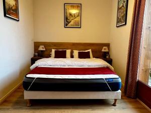 a bed in a bedroom with two pictures on the wall at Chalet rénové 6 pers, TV connectée, WiFi, parking, animaux admis - FR-1-504-480 in Le Dévoluy