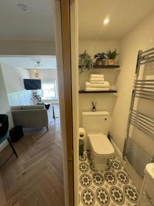 a bathroom with a toilet and a living room at Chestnut Cottage Ravensworth in Richmond