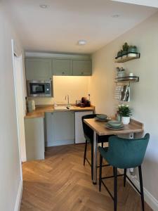 a kitchen with a table and chairs in a room at Chestnut Cottage Ravensworth in Richmond