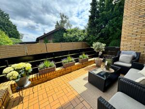 a patio with furniture and potted plants on it at Ferienhaus Zipfelstube in Selfkant