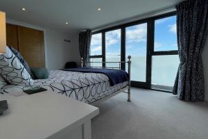ウーラクームにあるSeasalt - Beach Front Apartmentのベッドと大きな窓のある寝室