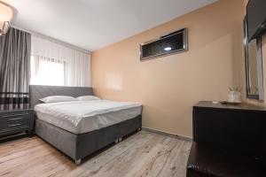a small bedroom with a bed and a window at Grand Taverna Boutique -Adults Only in Vama Veche