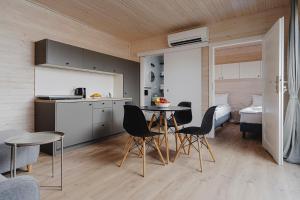 a kitchen and dining room with a table and chairs at BED & BIKE Resort Trzęsacz - domki, sauna, jacuzzi & rowery in Trzęsacz