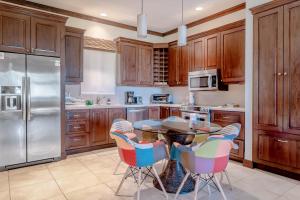 a kitchen with wooden cabinets and a table and chairs at Luxury, ocean view, 3-bedroom condo @ Los Sueños in Herradura